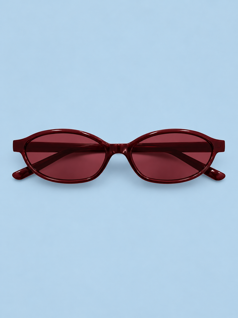Burgundy oval sunglasses with a glossy wine-red frame and matching tinted lenses on a milk blue background.